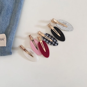 Detail showing set of six oval hair clips in various patterns with gold metal duckbill clips