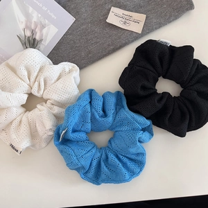 Détail de chouchous tricotés en bleu, blanc et noir avec texture maille ajourée fine