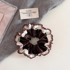 Detail of coffee brown velvet hair scrunchie with delicate white lace edging