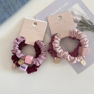 Detail of scrunchie sets with square beads and gold heart tags on card packaging