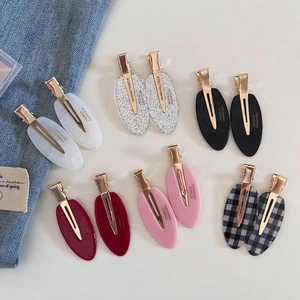 Detail view of acetate oval hair clips set with diverse marble and glitter patterns