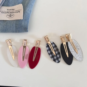 Handmade oval acetate hair clips in six colors with gold metal grip for elegant styling