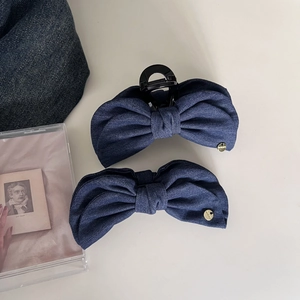 Vintage dark blue denim bow hair clip set with elegant gold brand tag and layered design