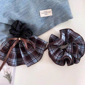 Detail of vintage blue and brown plaid ribbon bow scrunchie set on white background