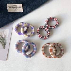 Detail view of colorful plaid fabric hair ties showing the knit texture and elasticity