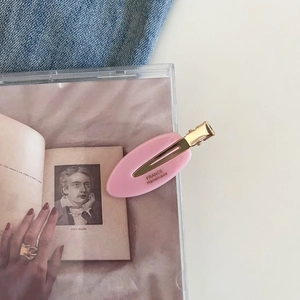 Detailed view of pink oval acetate hair clip with France Handmade gold engraving