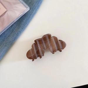 Close-up of elegant acetate hair claw clip with brown and white marble texture