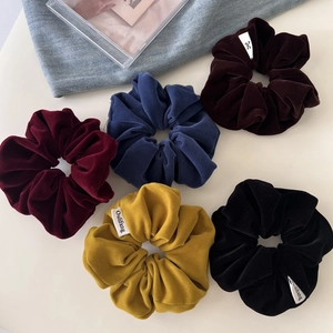 Detailed view of 5-pack velvet scrunchies in burgundy, navy, brown, yellow and black