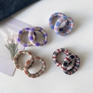 Close-up of seamless elastic checkered hair ties in four colorful patterns on white background