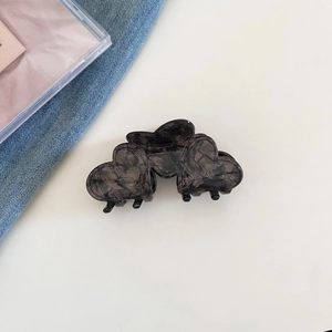 Macro view of dark grey marble heart hair claw clip in high-quality acetate material