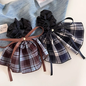 Detailed view of vintage plaid bow scrunchies with elegant blue and brown checkered patterns