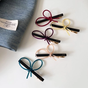 Detailed set of five acetate bow hair clips in multiple colors with gold metal grip