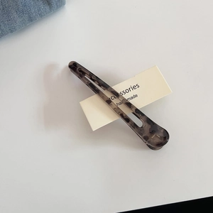 Dettaglio di una grande clip per capelli leopardata con trama in acetato e chiusura in metallo
