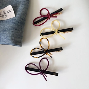 Detail view of acetate bow hair clips with gold label and France Handmade engraving