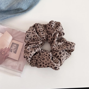 Stylish leopard print scrunchie for women made of soft textured fabric on white background