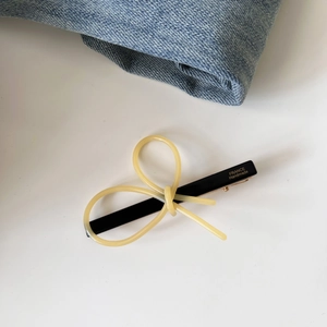 Detail view of acetate bow hair clip with gold label and FRANCE Handmade lettering