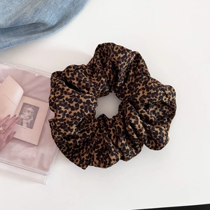 Close-up of leopard print oversized hair scrunchie with soft fabric texture and pleated design