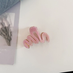 Pince à cheveux en acétate rose marbré avec bordure dorée et design ondulé minimaliste