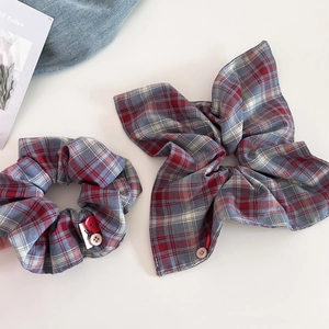 British style red and grey plaid scrunchie set with button details on a minimal background