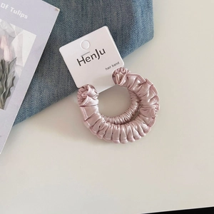 Vue détaillée des chouchous en satin rose avec une texture brillante et élastique premium