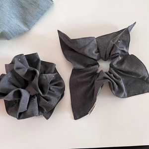 Set de chouchous gris foncé scintillants avec designs plissés et nœud sur fond blanc