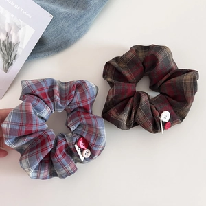 Macro shot of retro red and blue plaid scrunchies with decorative buttons and fabric texture