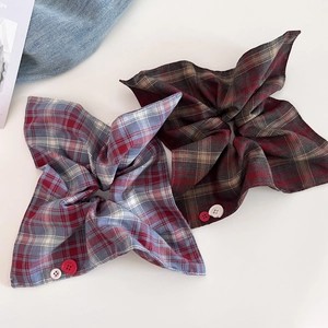 Detail view of plaid scrunchies with decorative faith and hope buttons on fabric