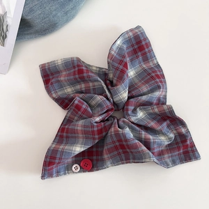 Close-up of red and blue checkered scrunchie with Faith & Hope engraved buttons