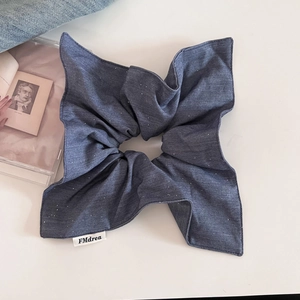 Détail du chouchou géant en denim bleu avec pois étoilés et étiquette FMdrea tissée