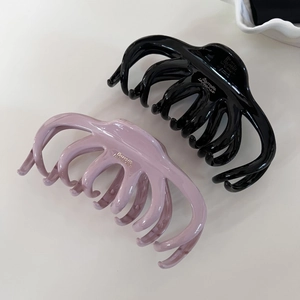 Large black and purple grey French hair claws for thick hair on a beige background