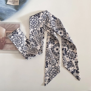 Dettaglio di una lunga sciarpa di seta blu navy con motivo paisley e geometrico vintage