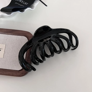 Detail showing the glossy black claw clip texture and Barrette La France branding
