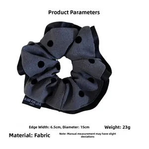 Detailed view of grey polka dot scrunchie hair tie with dimensions 15cm diameter