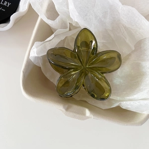 Macro shot of dark green flower hair claw clip with glossy resin and silver metal spring