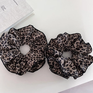 Set of two vintage leopard print scrunchies with black edges on white background
