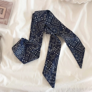 Dettaglio della sciarpa in seta blu navy con motivo paisley su tessuto bianco elegante