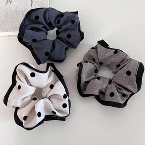 Three-piece set of elegant polka dot scrunchies in navy, grey, and cream colors