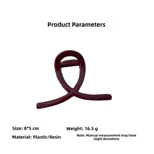 Dettaglio macro della pinza per capelli rosso vino con design lucido a nastro da 8x5cm