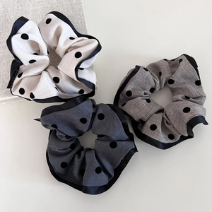 Set of three elegant polka dot scrunchies in white, light grey, and dark grey tones