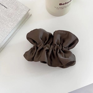 Détail d'un chouchou en satin marron foncé avec une élégante texture à double épaisseur