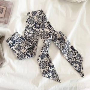 Dettaglio fascia per capelli in seta blu navy con eleganti motivi paisley e geometrici