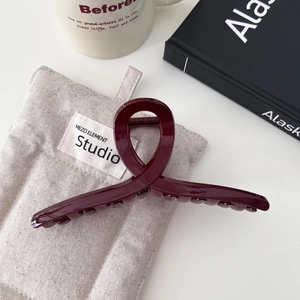Elegante pinza per capelli bordeaux grande per donna su sfondo di lino grigio con decori