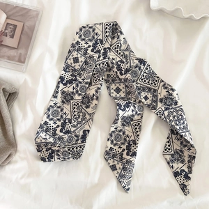 Dettaglio di un nastro di seta con motivo paisley blu navy su tessuto bianco