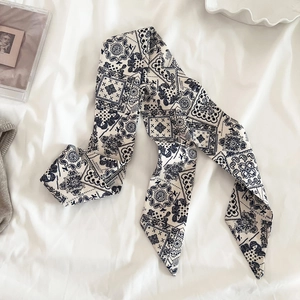 Dettaglio foulard twilly con stampa paisley retrò su sfondo in tessuto bianco morbido