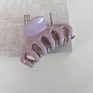 Pince à cheveux minimaliste violette brillante gravée Barrette La France sur un livre