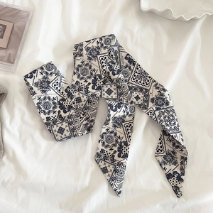 Dettaglio macro dello scialle twilly blu navy con motivi paisley e geometrici eleganti