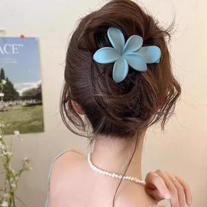 Eleganter mattblauer Morandi Blumen-Haarclip an einem Modell für einen schicken Look