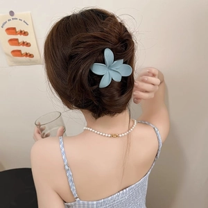 Rückansicht einer süßen blumenförmigen Haarspange in Morandi-Blau mit eleganter Perlenkette