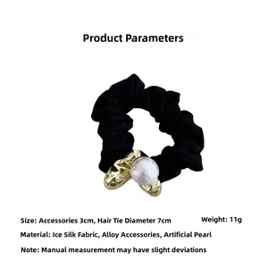 Détail d'un chouchou noir en soie glacée avec pendentif cœur de 3cm et perle