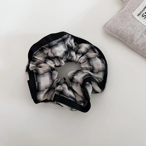 Plaid fabric scrunchie with black satin trim for elegant low ponytail hair styling